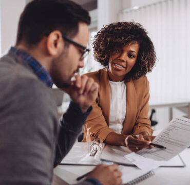 Woman having business meeting with colelague and together checking documentation